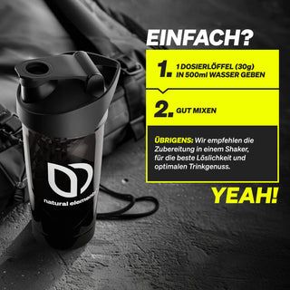 Eine schwarze Shakerflasche mit dem Logo von natural elements steht auf einer Fläche; eine Anleitung auf Deutsch beschreibt, wie man ein Pulver mit Wasser mischt.